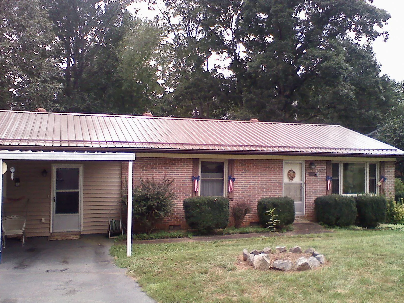 Bronze metal roof and carport on a brick ranch home — Roof Repair work by our crew in Mount Holly